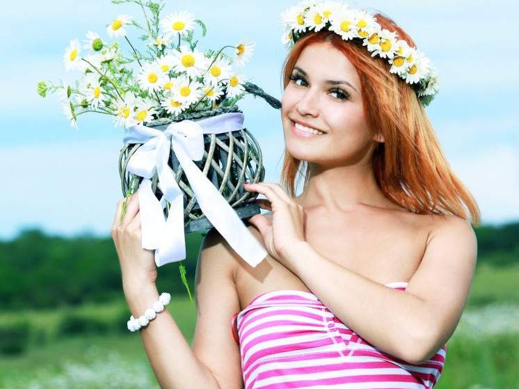 Красивая девушка посреди ромашек на фото