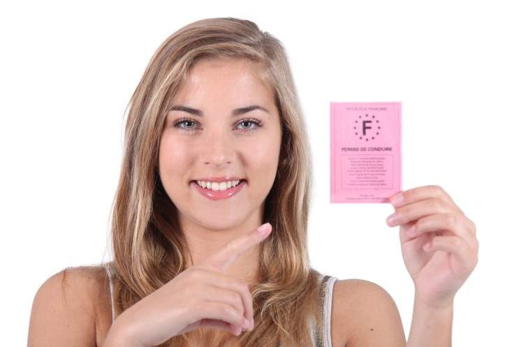 Красивая девушка с правами в руках на фото