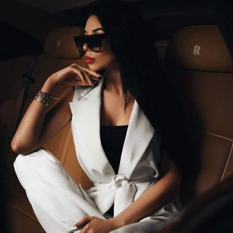 Красивая девушка в черном красивое платье и очках на фото