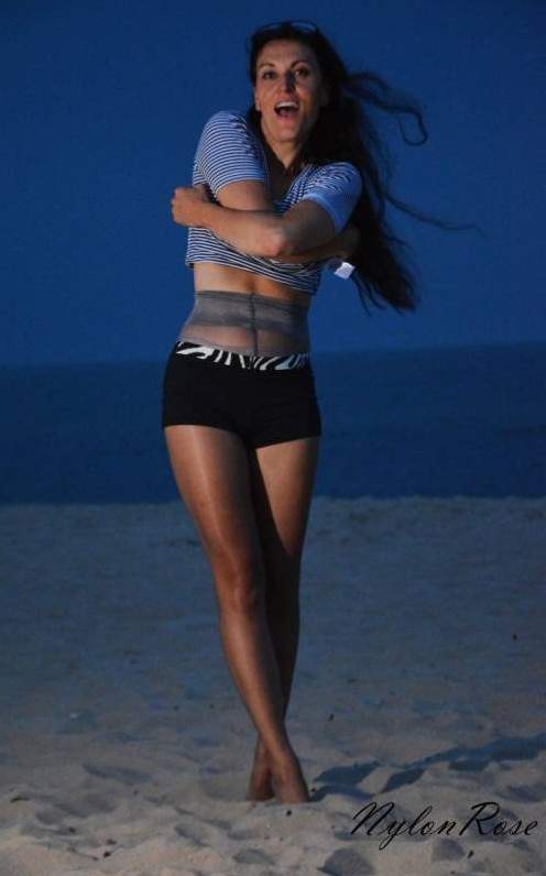 Красивая девушка в колготках на пляже на фото