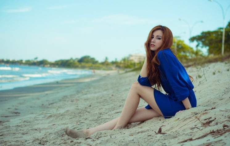 Рыжеволосая красивая девушка на пляже на фото
