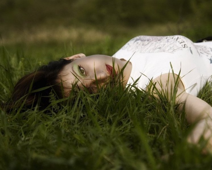 Красивая девушка лежащая на травке на фото
