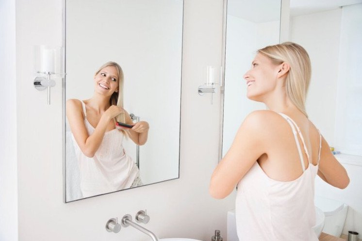 Красивая девушка перед зеркалом в ванной