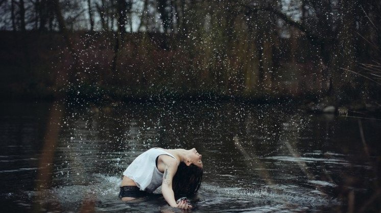 Красивая девушка под дождиком на природе на фото