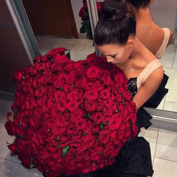 Красивая девушка с букетом бардовых роз