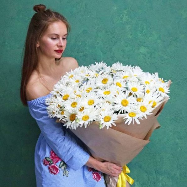 Красивая девушка с ромашками в машине