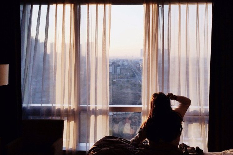 Красивая девушка спиной около окна