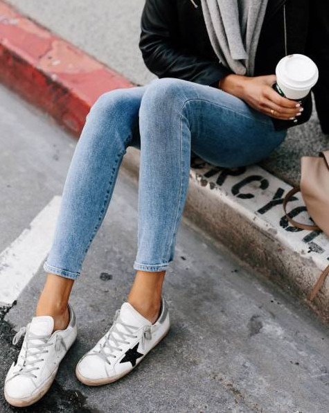 Красивая девушка в джинсах и кроссовках