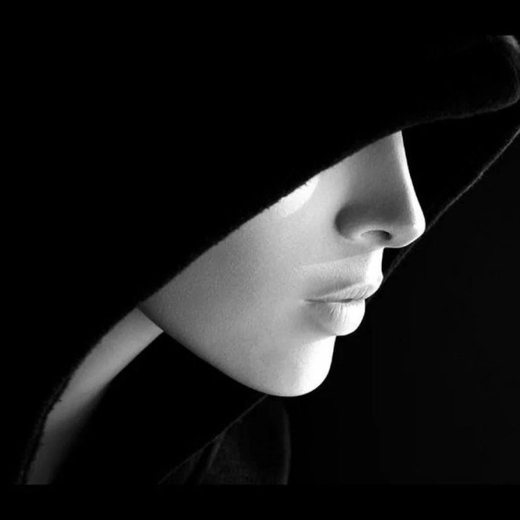 Красивая девушка в капюшоне боком на фото