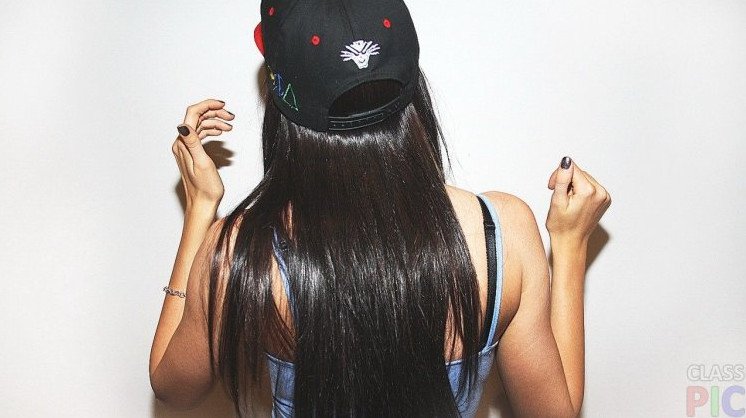 Красивая девушка в кепке спиной