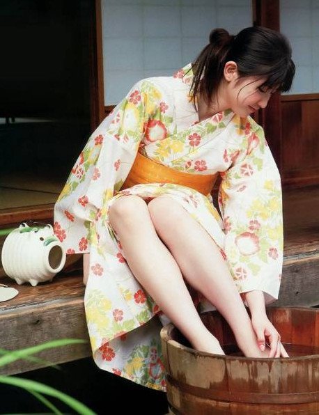 Красивая девушка в кимоно с босыми ногами на фото