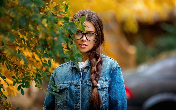 Красивая девушка в очках с косичками на фото