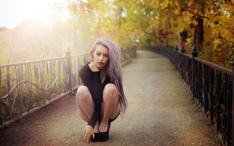 Красивая девушка в парке на лавке на фото