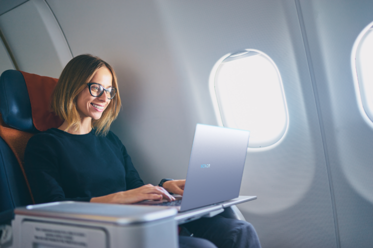 Красивая девушка в самолете с ноутбуком на фото