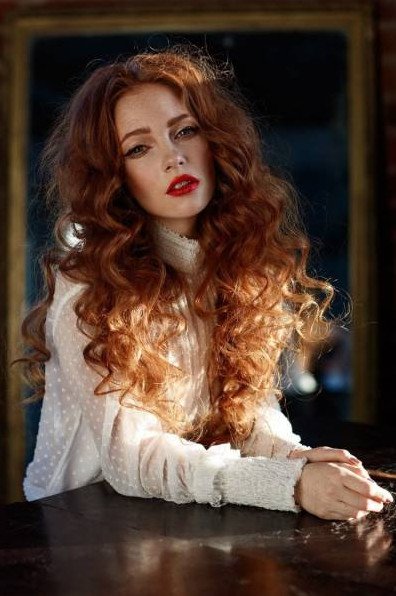 Рыжеватая красивая девушка с длинющими кучерявыми волосами на фото