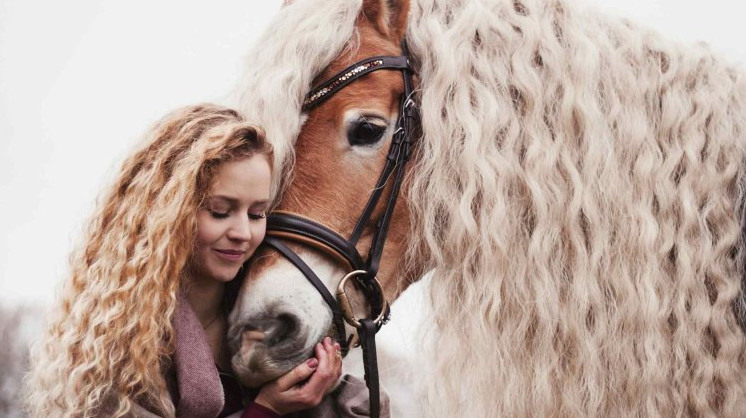 Красивая девушка на коне с длинными волосами.